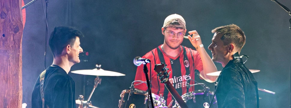 Drei Männer, die auf einer Bühne einen Auftritt haben