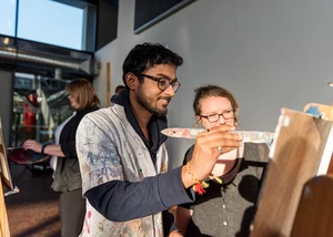 Zwei Menschen an einer Leinwand, die am Zeichnen sind