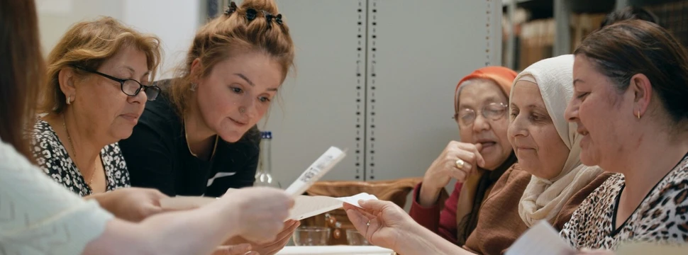 Mehrere Frauen, die in einem Raum Briefe lesen
