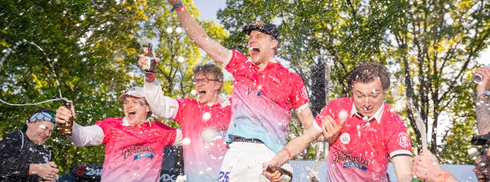 Vier junge Männer in Trikots, die ausgiebig ihren Weltmeistertitel feiern, den sie bei der diesjährigen Flunkyball WM gewonnen haben