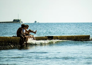 Personen am Steg im Meer