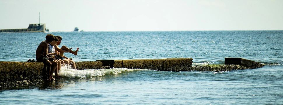 Personen am Steg im Meer