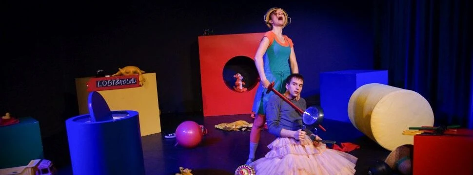 Mädchen hält anderen Jungen ein Holzschwert an die Kehle