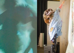 kleines Mädchen springt um mit einem Pinsel auf eine Wand zu malen