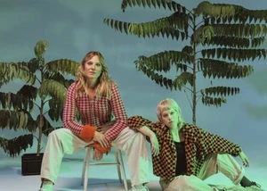 Zwei Frauen sitzen vor zwei Pflanzen