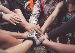Mehrere Hände von Menschen, die in der Mitte des Bildes einen Haufen bilden