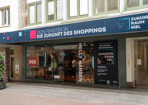 Der Zukunftsraum Kiel öffnet neue Wege für den Einzelhandel Schaufenster mit tiefblauem Schild in der Innenstadt