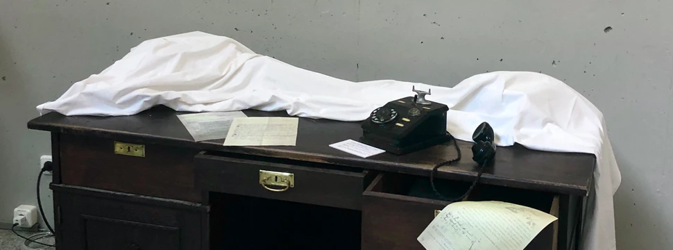 Die Audioinstallation macht das persönliche Schicksal der ermordeten Bibliothekarin lebendig Tisch mit altem Telefon und Dokumenten