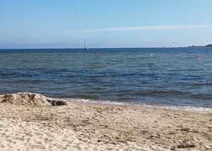 Der Falckensteiner Strand an der Kieler Förde bei blauem Himmel mit wenig Wolken