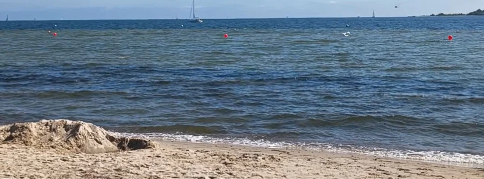Der Falckensteiner Strand an der Kieler Förde bei blauem Himmel mit wenig Wolken