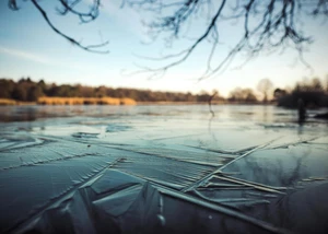 Ein See, auf dem das Wasser gefroren ist und mit blauem Horizont im Hintergrund