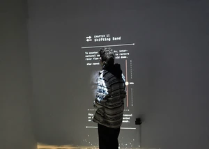 Ein Mann vor einer Wand, die von einem Projektor angestrahlt wird