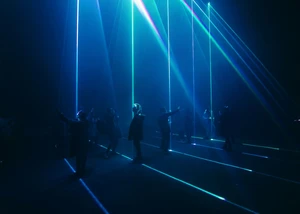 Menschen in einem Raum voller blauen Laserstrahlen