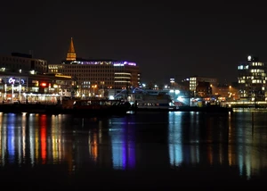Blick vom Wasser auf eine beleuchtete Stadt