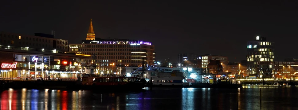 Blick vom Wasser auf eine beleuchtete Stadt