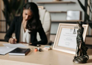 Rechtsanwältin am Schreibtisch Rechtsanwältin sitzt am Schreibtisch und unterschreibt ein Dokument
